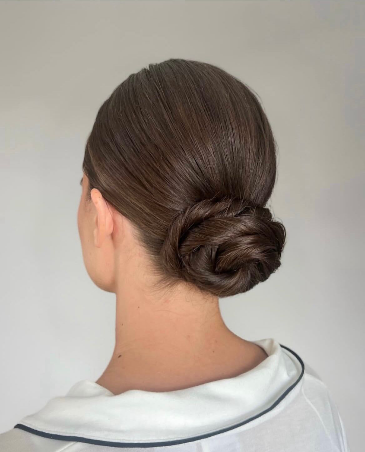 Sleek polished low bun styled close to the head.