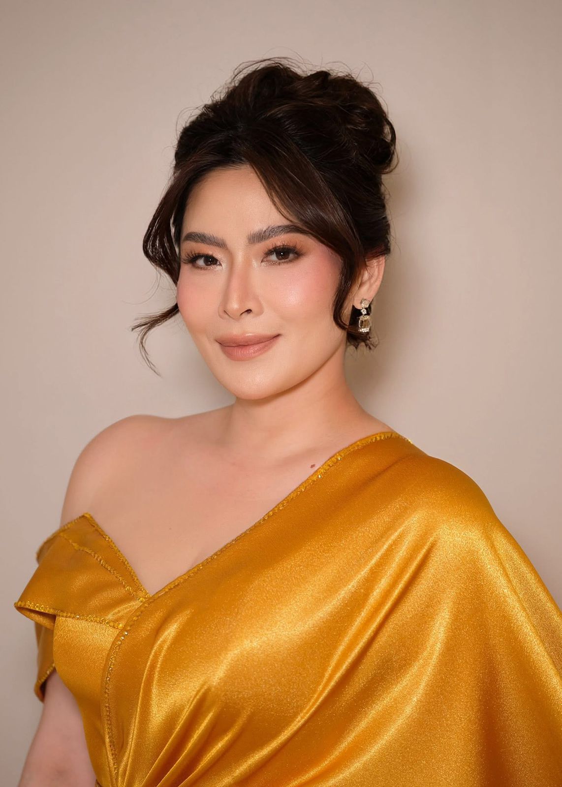Natural radiance — luminous complexion, soft updo, gold satin styling.
